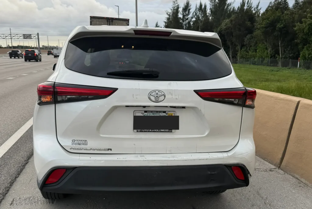 White SUV with minor rear bumper damage following a minor traffic accident.